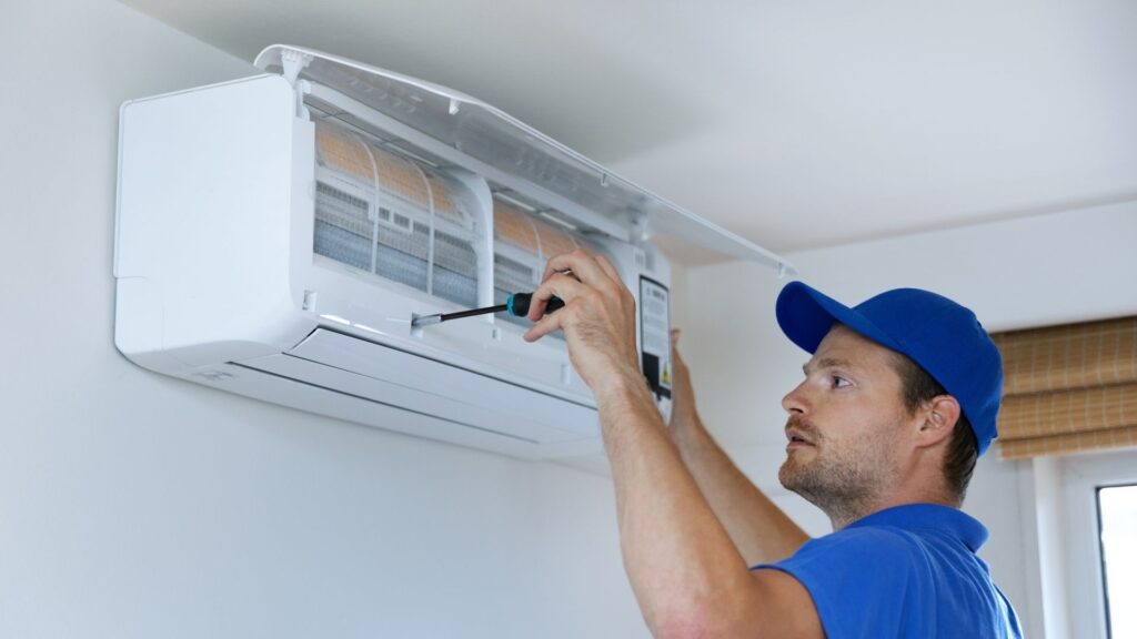 Technician cleaning a ductless mini-split indoor unit