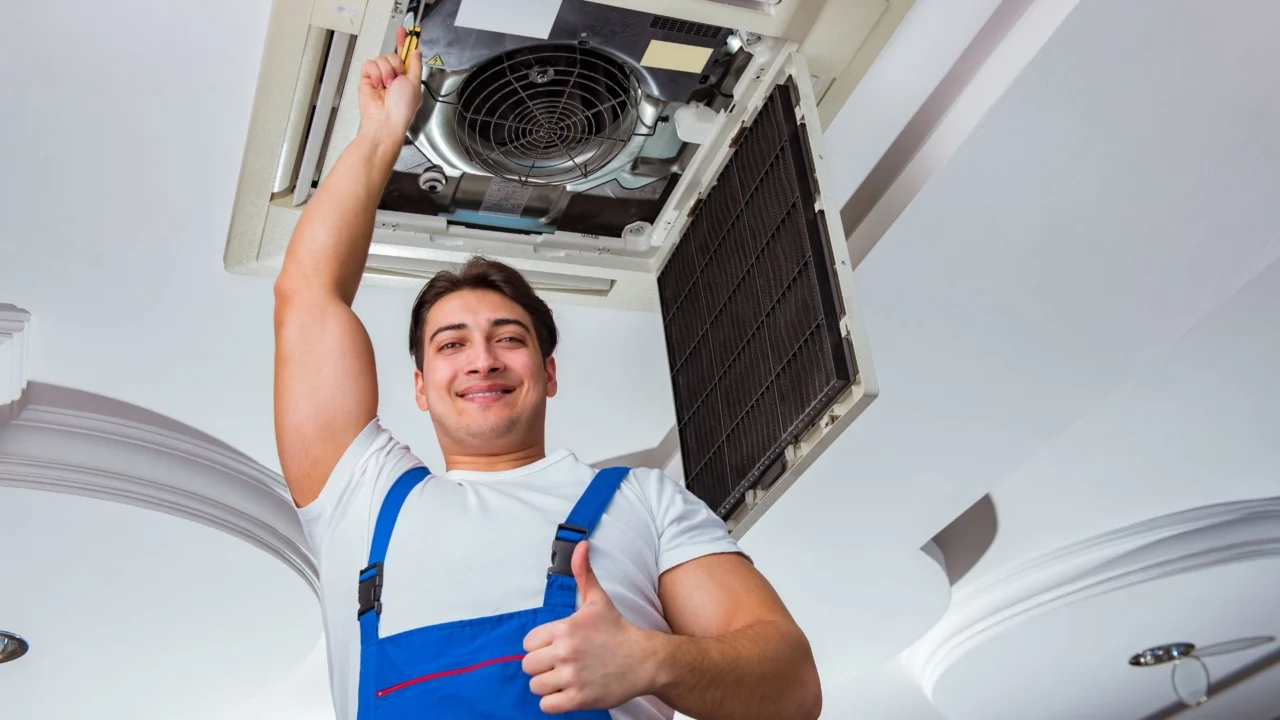 Technician installing a ceiling-mounted ductless mini-split