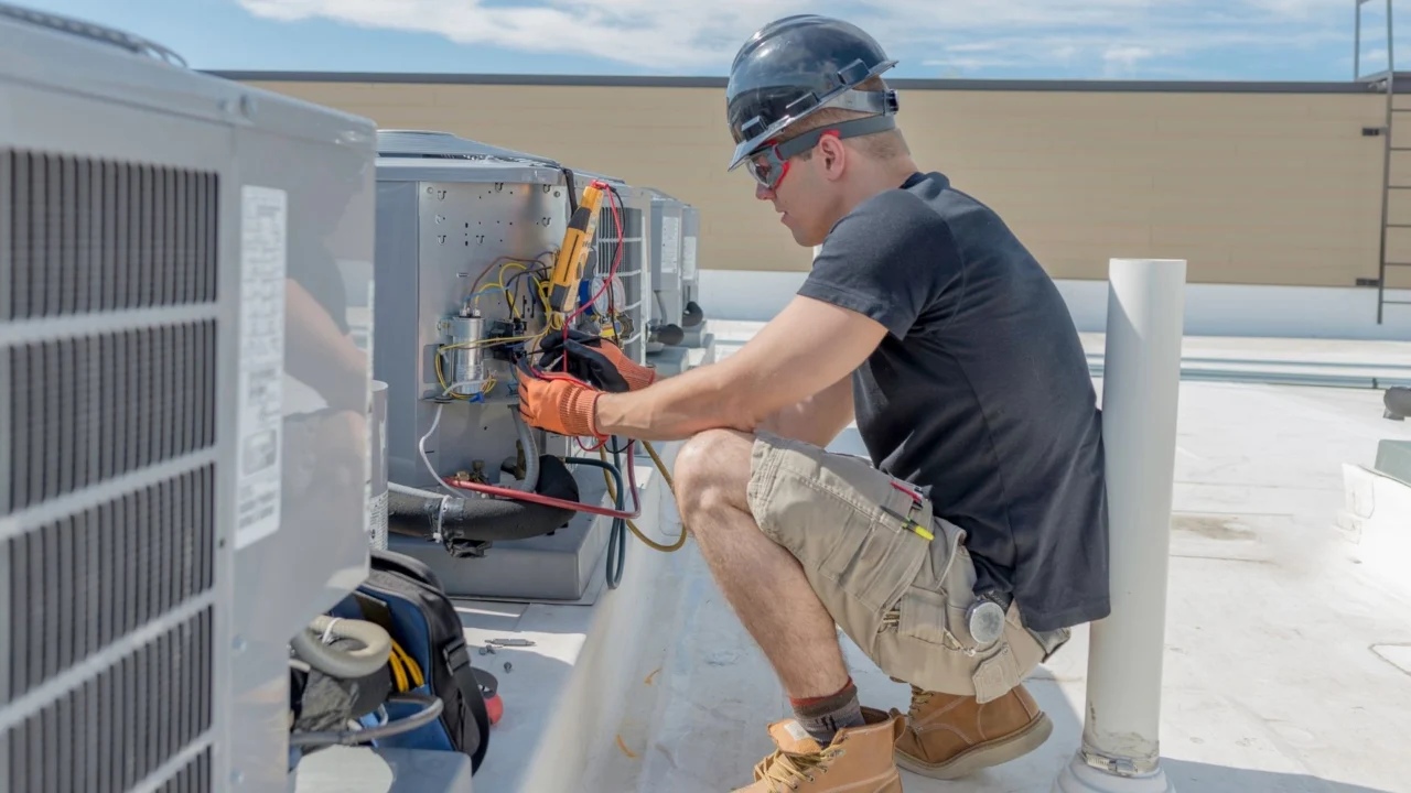 Technician servicing rooftop air-conditioning equipment