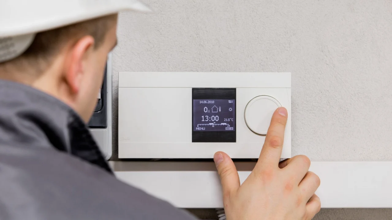 Technician adjusting a smart thermostat
