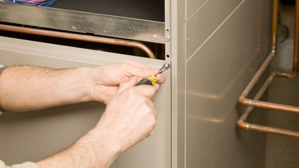 Technician repairing residential furnace equipment