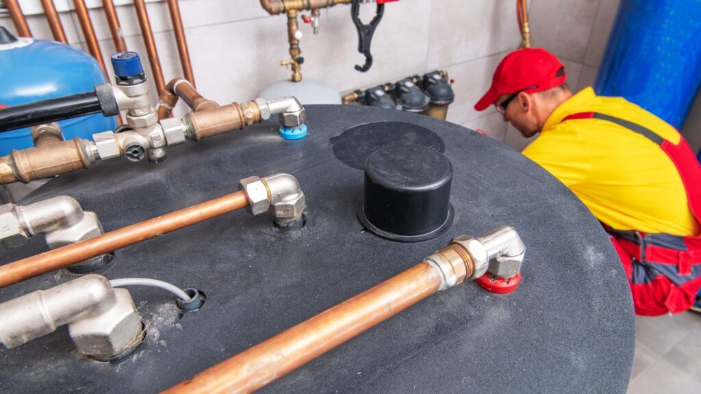 Technician working on hydronic heating pipes