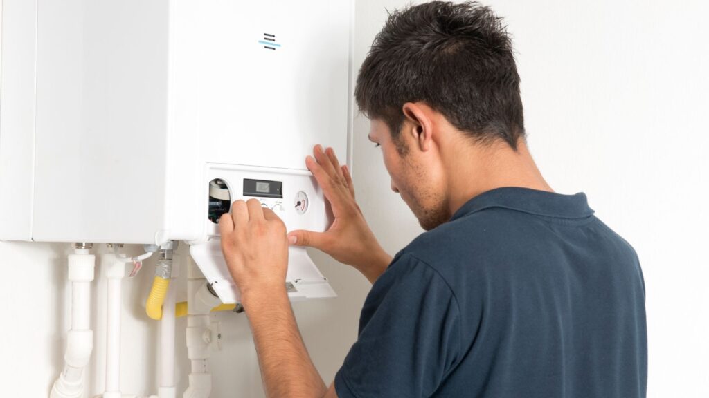 Technician servicing a wall-mounted boiler