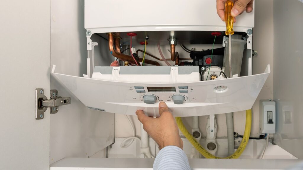 Technician servicing a wall-mounted boiler