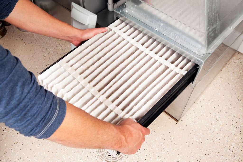 Homeowner replacing a furnace air filter