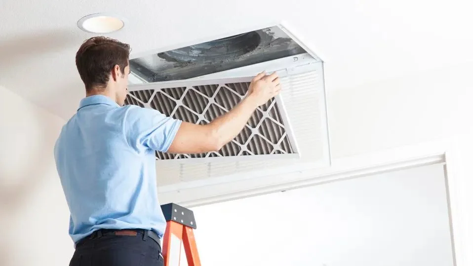 Air duct cleaning technician replacing an HVAC filter