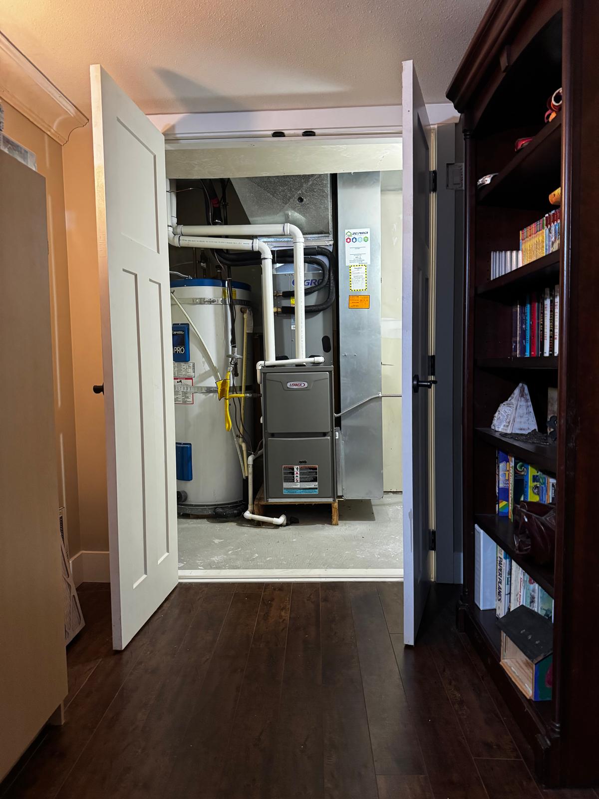 Residential furnace installed in a hallway utility closet
