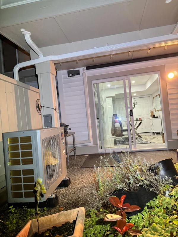 Outdoor heat-pump unit near a residential entry