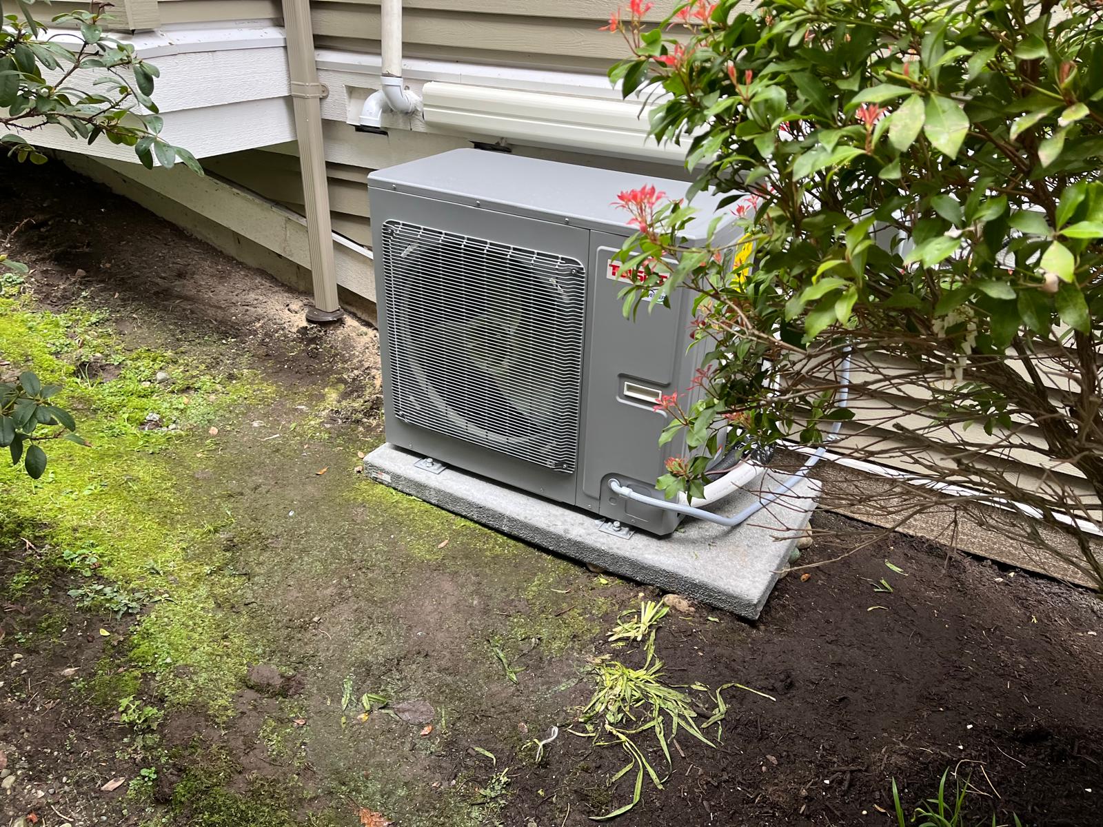 Outdoor heat-pump unit beside landscaping