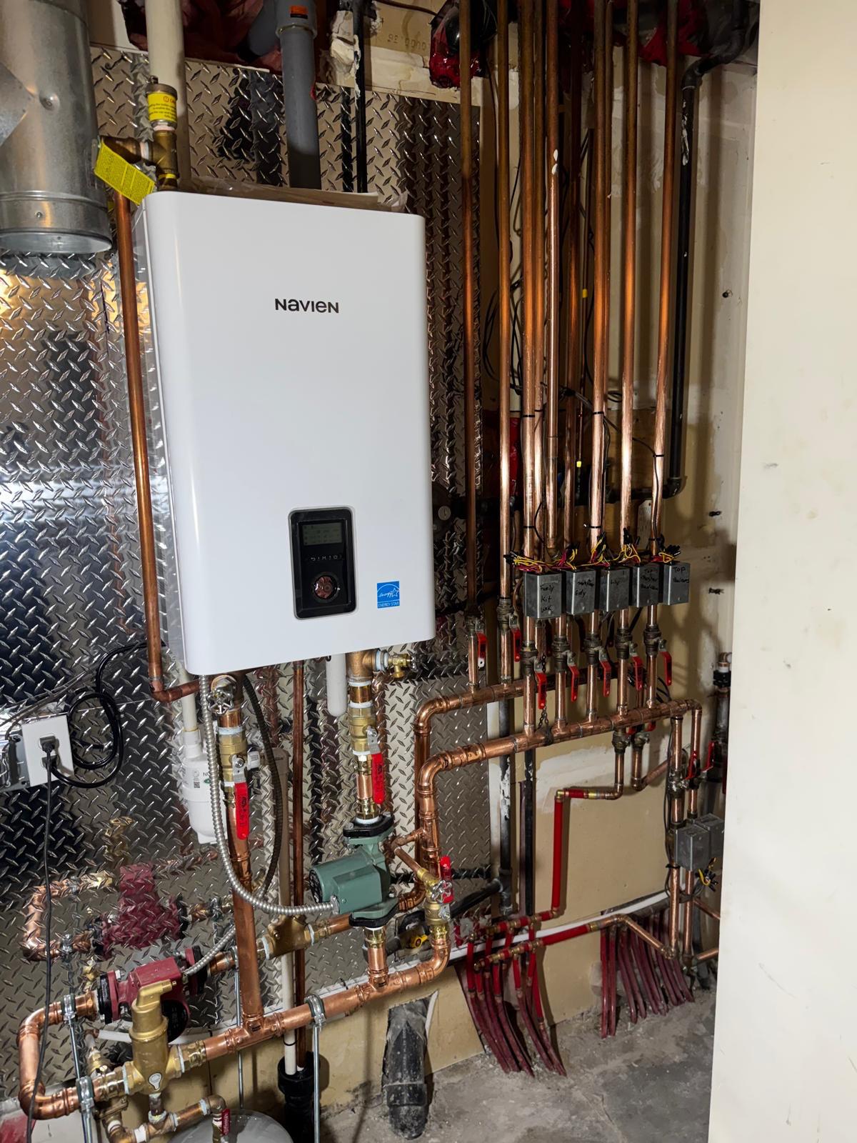 Tankless water heater with hydronic piping manifold
