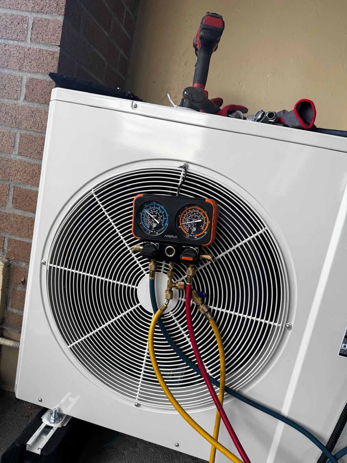Technician gauges connected to an outdoor air conditioner