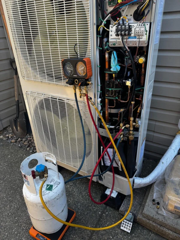 Technician gauges connected to an outdoor heat pump