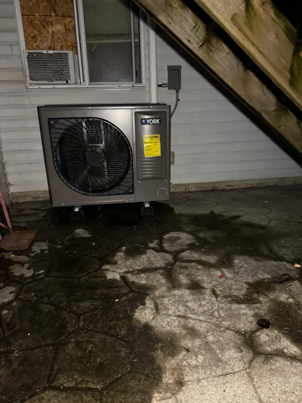 Outdoor heat-pump condenser beside a home